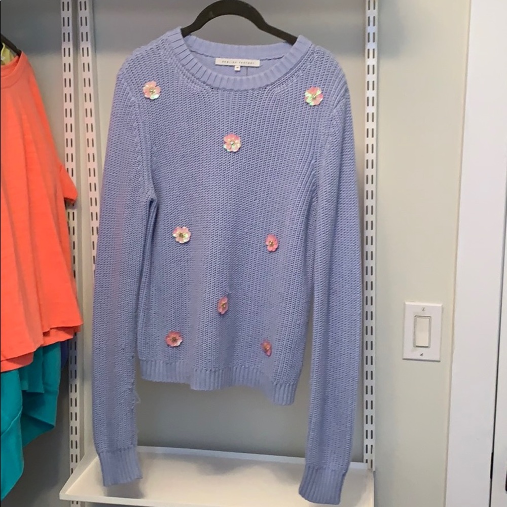 A light blue sweater with flower detailing
